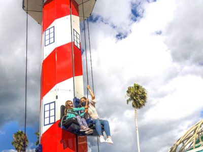 Riders on Lighthouse Lift-off seaside park ride